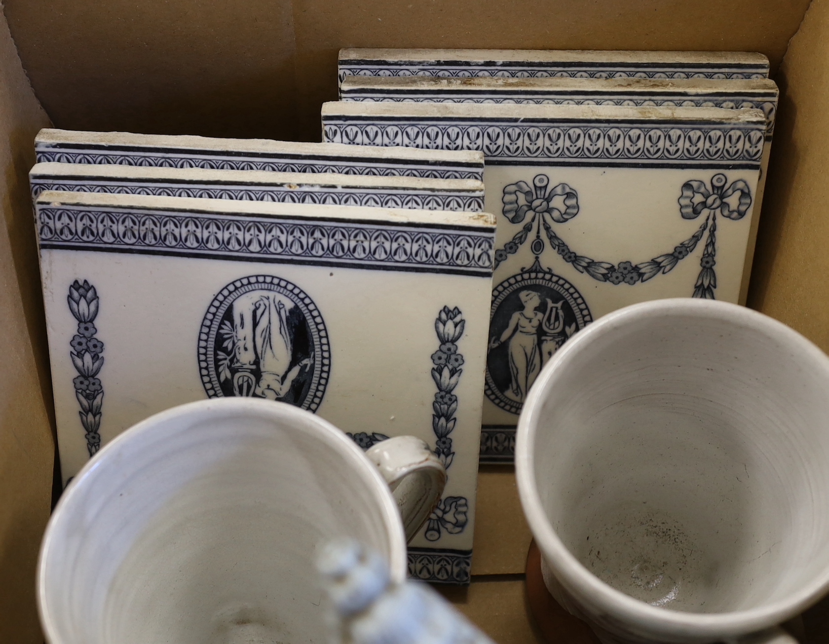 A set of Wedgwood blue and white tiles, a jug signed W Ridgway, a Staffordshire watch stand and two commemorative mugs, the largest 24cm high